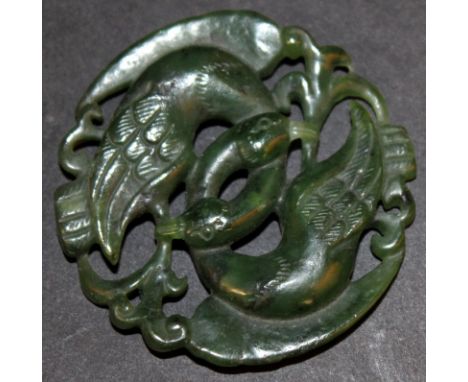 A CHINESE CARVED AND PIERCED SPINACH-GREEN JADE CARVING, in the form of a pair of entwined birds, 2.1in diameter.