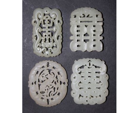 A GROUP OF FOUR CHINESE JADE-LIKE PLAQUES & PENDANTS, each with pierced decoration, the longest 2.3in high.
