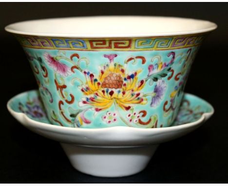 AN EARLY 20TH CENTURY CHINESE FAMILLE ROSE PORCELAIN CUP & STAND, each piece painted with formal scroll-stemmed flowerheads r