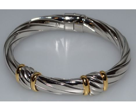 A STERLING SILVER TWO COLOUR HINGED BANGLE.