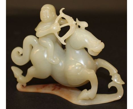 A CHINESE JADE-LIKE CARVING OF AN ARCHER, mounted on a galloping horse, 5.5in long.