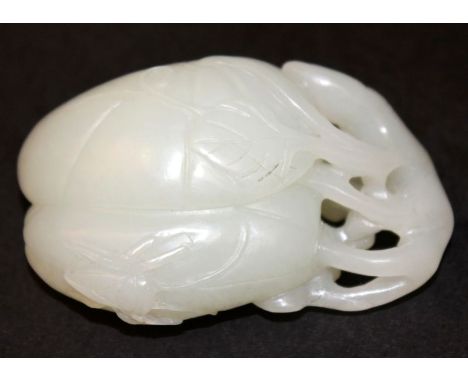 A CHINESE JADE CARVING OF A FRUIT, decorated naturalistically in low relief with an insect and leafage, 2.25in long.