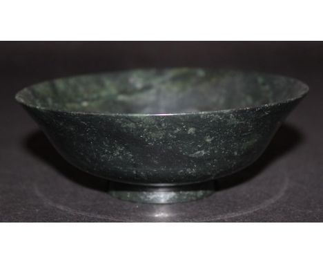 A CHINESE JADE-LIKE BOWL, of spinach-green tone with lighter areas, 5in diameter.