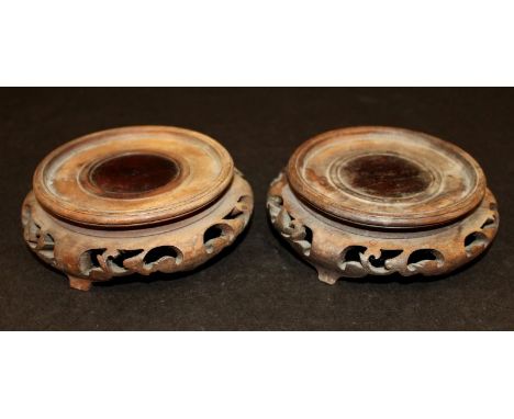 A PAIR OF EARLY 20TH CENTURY CHINESE CARVED HARDWOOD VASE STANDS, each carved and pierced to the sides with ruyi and scroll w