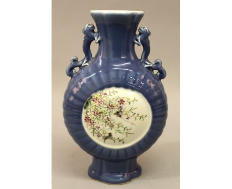  A GOOD QUALITY CHINESE FAMILLE ROSE BLUE-GROUND PORCELAIN MOON FLASK, supported on a splayed foot, painted to one side with 