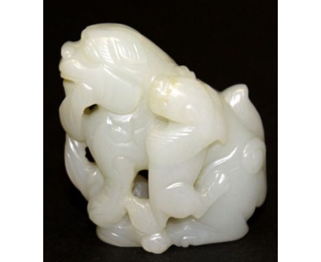 A CHINESE WHITE JADE CARVING OF A BUDDHISTIC LION & PUP, 2in high.
