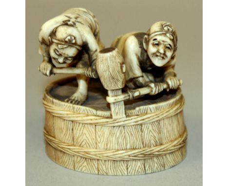 A GOOD QUALITY SIGNED JAPANESE MEIJI PERIOD IVORY OKIMONO OF TWO BARREL MAKERS, energetically adjusting the rope binding with