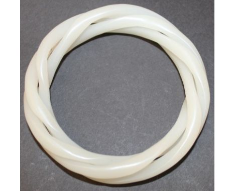 A CHINESE WHITE JADE-LIKE THREE-STRAND BANGLE, 3.25in diameter, the inner rim approx. 2.3in diameter.