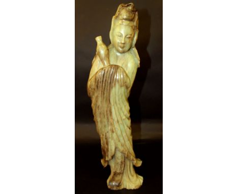 A LARGE CHINESE JADE LIKE HARDSTONE FIGURE OF GUANYIN, her curving form dressed in flowing robes, the Goddess holding a vase,