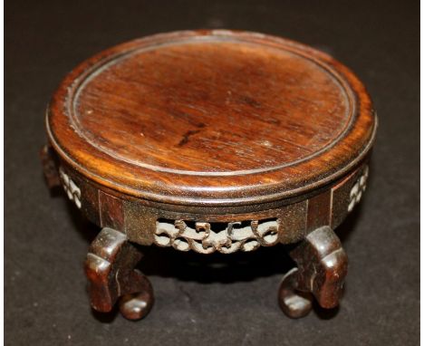 AN EARLY 20TH CENTURY CHINESE CARVED HARDWOOD VASE STAND, supported on scroll feet, the sides carved and pierced with scroll 