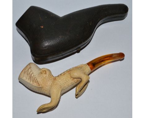 A 19TH CENTURY RARE CARVED PIPE with amber mouth piece, the bowl and body as a crocodile, 6ins long, in a leather case.