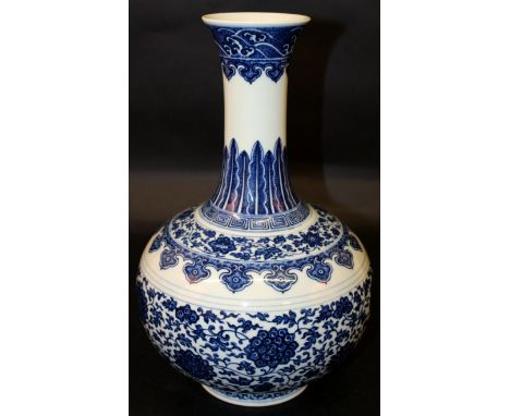 A CHINESE MING STYLE BLUE & WHITE PORCELAIN BOTTLE VASE, the sides decorated in a ‘heaped and piled’ manner with formal scrol