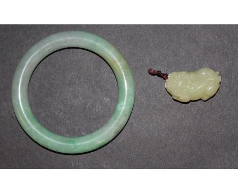 A CHINESE JADE BANGLE, 3.25in diameter, the inner rim 2.3in diameter; together with a small jade-like carving of a buddhistic