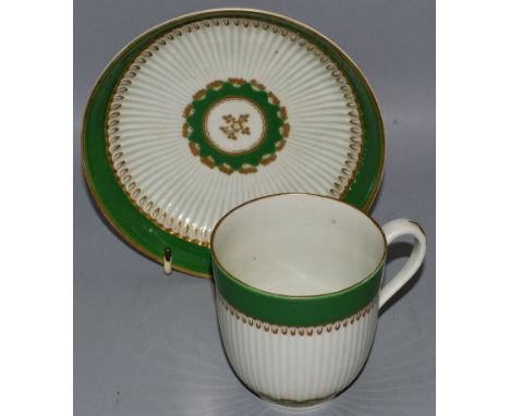 AN 18TH CENTURY WORCESTER COFFEE CUP AND SAUCER of ribbed form painted with two apple green and gilt borders.