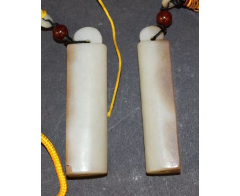 A PAIR OF CHINESE JADE PENDANTS, with tassel attachments possibly costume accessories, each pendant 2.9in high.