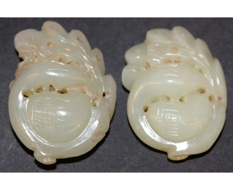 A SMALL PAIR OF 19TH CENTURY CHINESE JADE CARVINGS, each carved and pierced in the form of a phoenix, 1.75in & 1.6in high.