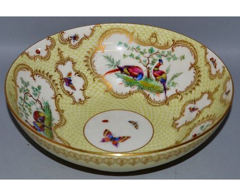 A ROYAL WORCESTER YELLOW SCALE BOWL painted with exotic birds in gilt mirror panels signed by JOHN FREEMAN date code for 1931