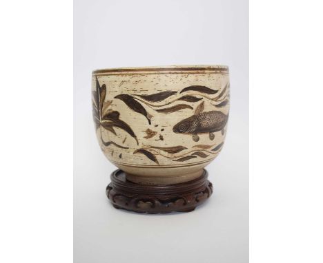 Interesting Asian pottery bowl decorated with fish, possibly Korean, 19cm diam, on wooden stand