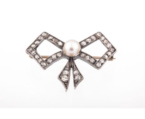 An early 20th century cultured-pearl and diamond bow brooch. Centred with a 5.7mm round cultured-pearl between open angular b