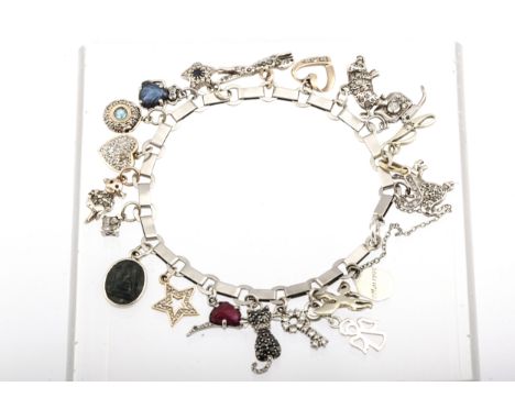 A 1940s French platinum bracelet in the manner of Boucheron hung with 21 various charms. The bracelet struck three times with