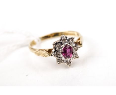 A vintage 18ct gold, ruby and diamond oval cluster ring. Centred with an oval mixed-cut ruby, claw set within a small eight-c