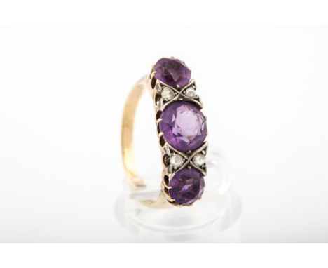 A vintage amethyst and diamond dress ring. The three graduated round mixed-cut amethysts spaced by pairs of small rose diamon