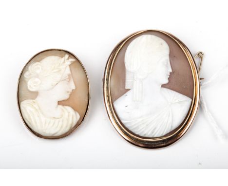 Two vintage gold and shell cameo oval brooches. Each depicting a neoclassical female bust, facing right. The smaller cameo la