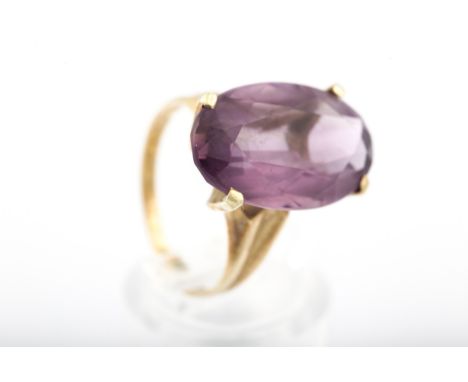 A vintage Continental gold and amethyst single stone ring. The oval mixed-cut stone in a four claw setting on a 'D' section s