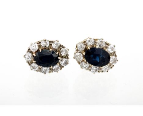 A pair of vintage gold, sapphire and diamond oval cluster stud earrings. Each claw set at the centre with an oval mixed-cut s