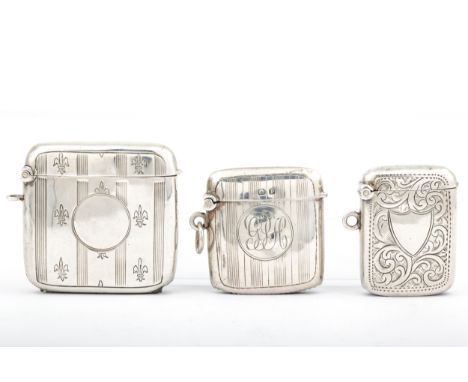 Three early 20th century silver vesta or match cases. Comprising; a smaller example all-over engraved with scrolling leaves a