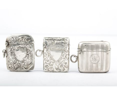 Three early 20th century silver vesta or match cases. Comprising; one with engine turned bands and a round reserve with scrip