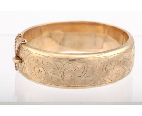 A vintage 9ct gold part foliate engraved hollow half-hoop hinged bangle. Hallmarks for Birmingham 1970, 29mm wide, 5mm high, 