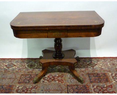 A Regency Rosewood Brass Inlaid Card Table, the hinged top enclosing a baize lined interior above a plain frieze, raised upon