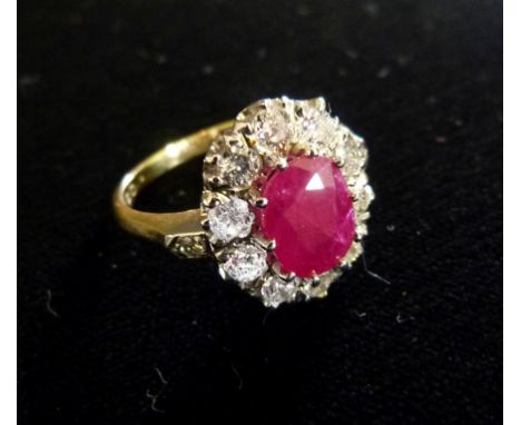 An 18ct. Yellow Gold Ruby and Diamond Cluster Ring, with a central oval ruby surrounded by diamonds within a pierced setting