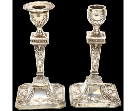 A pair of George V Neo-Classical style table candlesticks, Atkin Brothers, Sheffield 1924, relief embossed decoration with re
