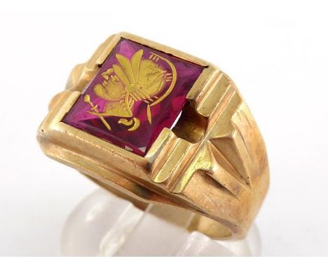 A gentleman's yellow metal (tests 14 carat gold) signet ring, set with a synthetic ruby intaglio, finger size T/U, 6.9gms 