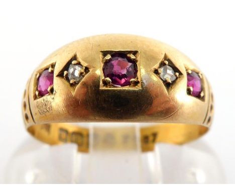 A late Victorian 18 carat gold, ruby and diamond ring, gypsy set with round cut rubies, small rose cuts between, shank fully 