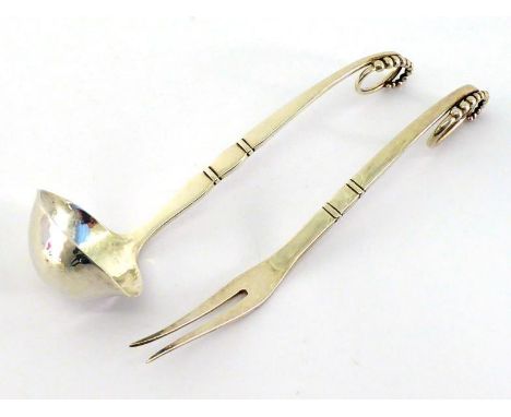 Georg Jensen:- A Danish silver sauce ladle together with a two-prong pickle fork, both of No. 41 pattern, post 1945,  oval lo