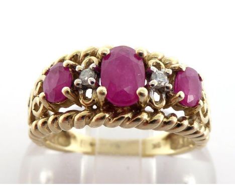 A 9 carat gold, ruby and diamond ring, the openwork scroll mount set with three graduated rubies, the largest 6 x 4mm, small 