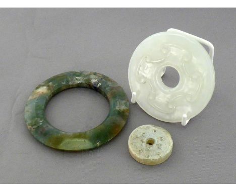 A group of three Chinese carved archaic style jade and moss agate Bi, 19th/20th century, largest one 6cm diam.; smallest one 