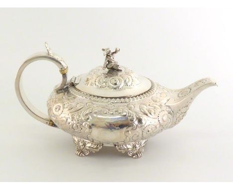 A George IV compressed circular silver teapot by Hyam Hyams, London, 1822, sides chased with flowers around a vacant cartouch