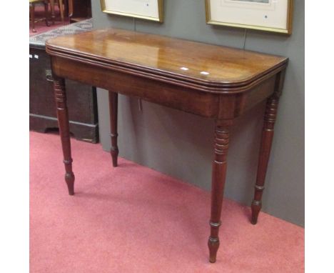 A Regency mahogany fold over card table, on ring turned legs 
