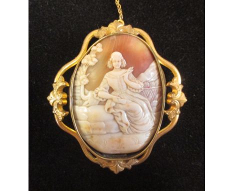 A shell cameo depicting a late 17th century lady in a rustic landscape, the large oval portrait format cameo showing a seated