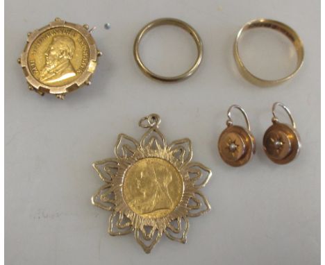 An 1895 South African half pond in a 9ct mount, an 1898 half sovereign in a 9ct mount, an 18ct wedding band, a 9ct wedding ba