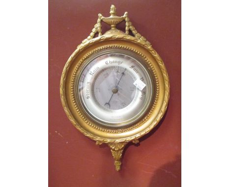 An aneroid wall barometer in a gilt frame 