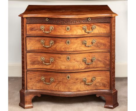 A George III mahogany serpentine fronted chest, of four graduated long drawers with original foliate gilt brass handles and p