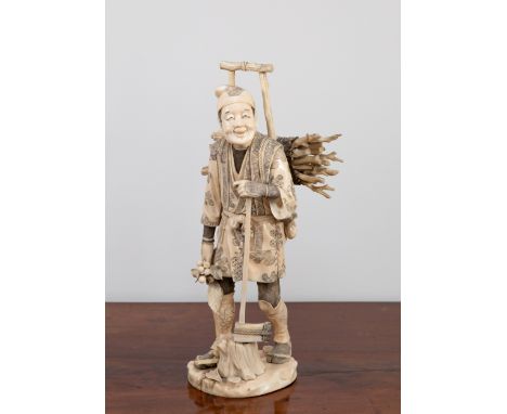 A Japanese carved sectional ivory figure of a woodcutter, Meiji period (1868-1912), standing with a bundle of sticks on a fra