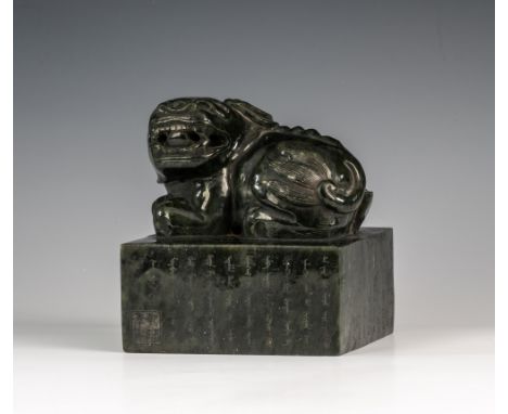 A large Chinese carved dark spinach jade seal, 19th / 20th century, of near square section surmounted with a recumbent kylin,