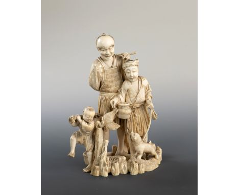 A Japanese carved ivory okimono of a man, woman and child, Meiji period (1868-1912), the man holding a tobacco pipe, the lady