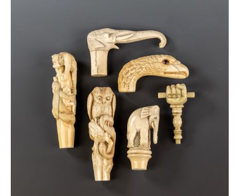 Six carved ivory walking cane handles, comprising an eagle head with glass eyes, c.1890; a standing elephant, c.1900; an elep